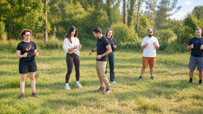 Pratique des baguettes de sourcier en groupe dans la nature Groupe pratiquant avec des baguettes de sourcier dans un espace naturel.